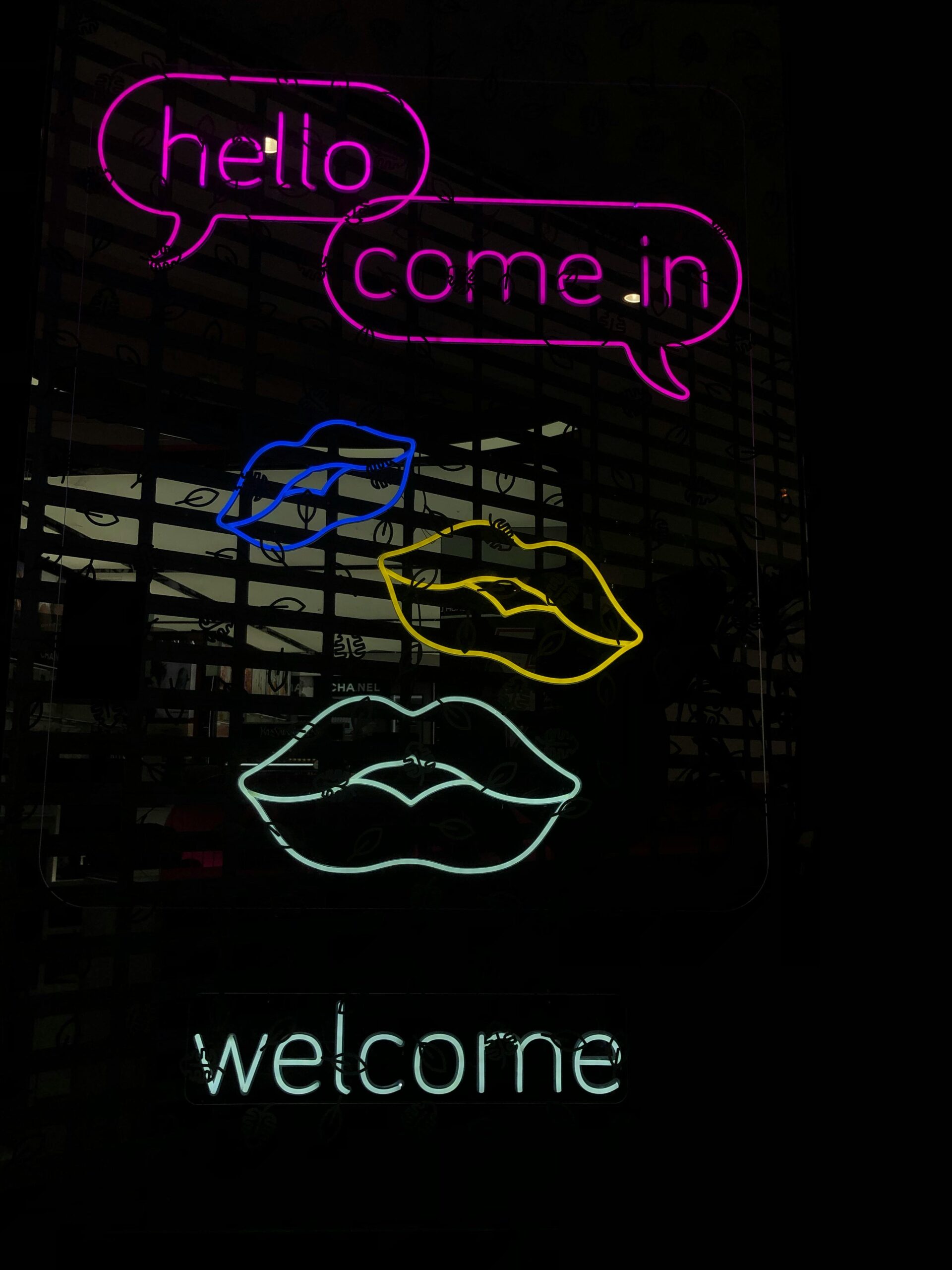 Neon sign that says Hello, Come In with 3 neon lips
